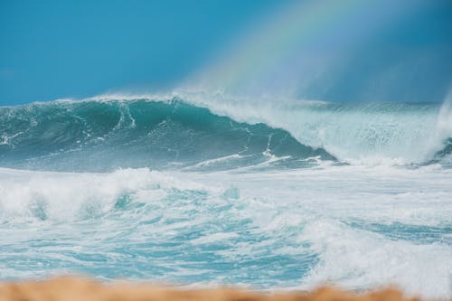 Ocean Waves under Blue Sky with Rainbow