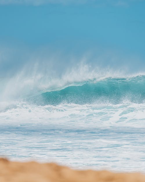 Ocean Waves Crashing on Brown Sand