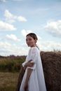 A Woman in White Sleeve Dress Standing on Brown Grass Field