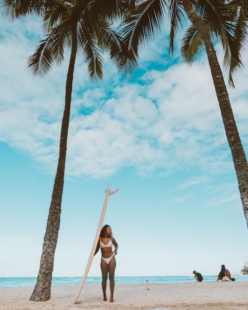 Woman Standing on a Beach with a Surfboard 