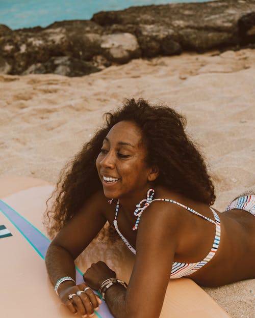 Smiling Woman in Bikini Lying on Beach