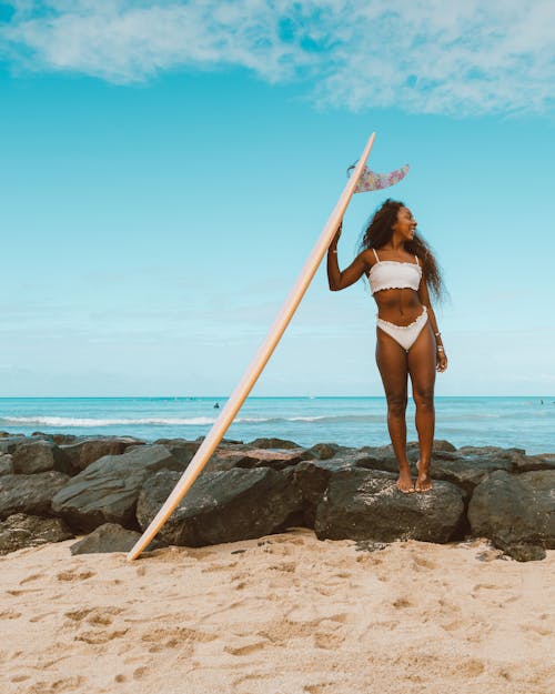 Woman with Surfboard on Rocks