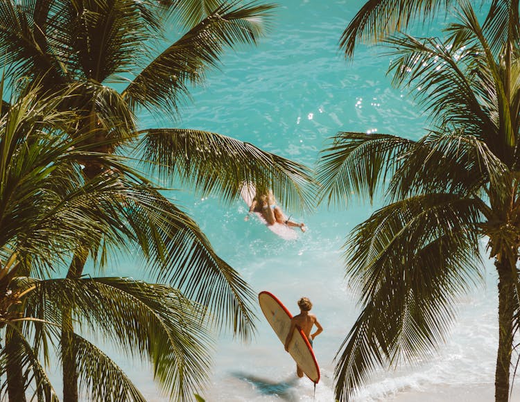 People With Surfboards On A Beach