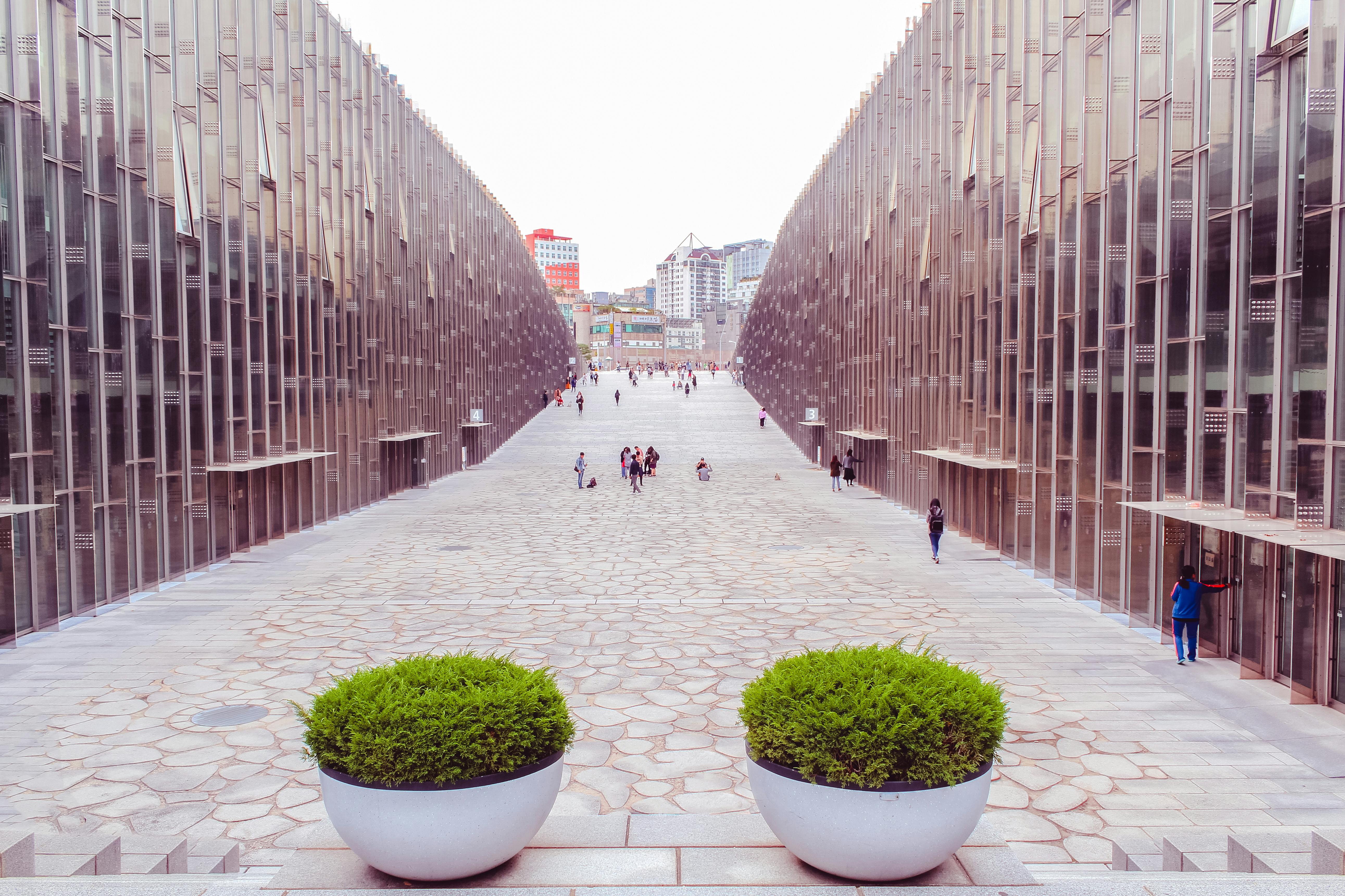 People walking in a modern university campus surrounded by contemporary architecture in Seoul, South Korea.
