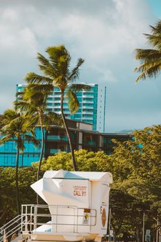 A scenic tropical beach with palm trees and lifeguard tower in a resort setting.