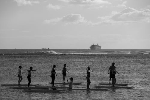 People on Surfboards on Sea Shore