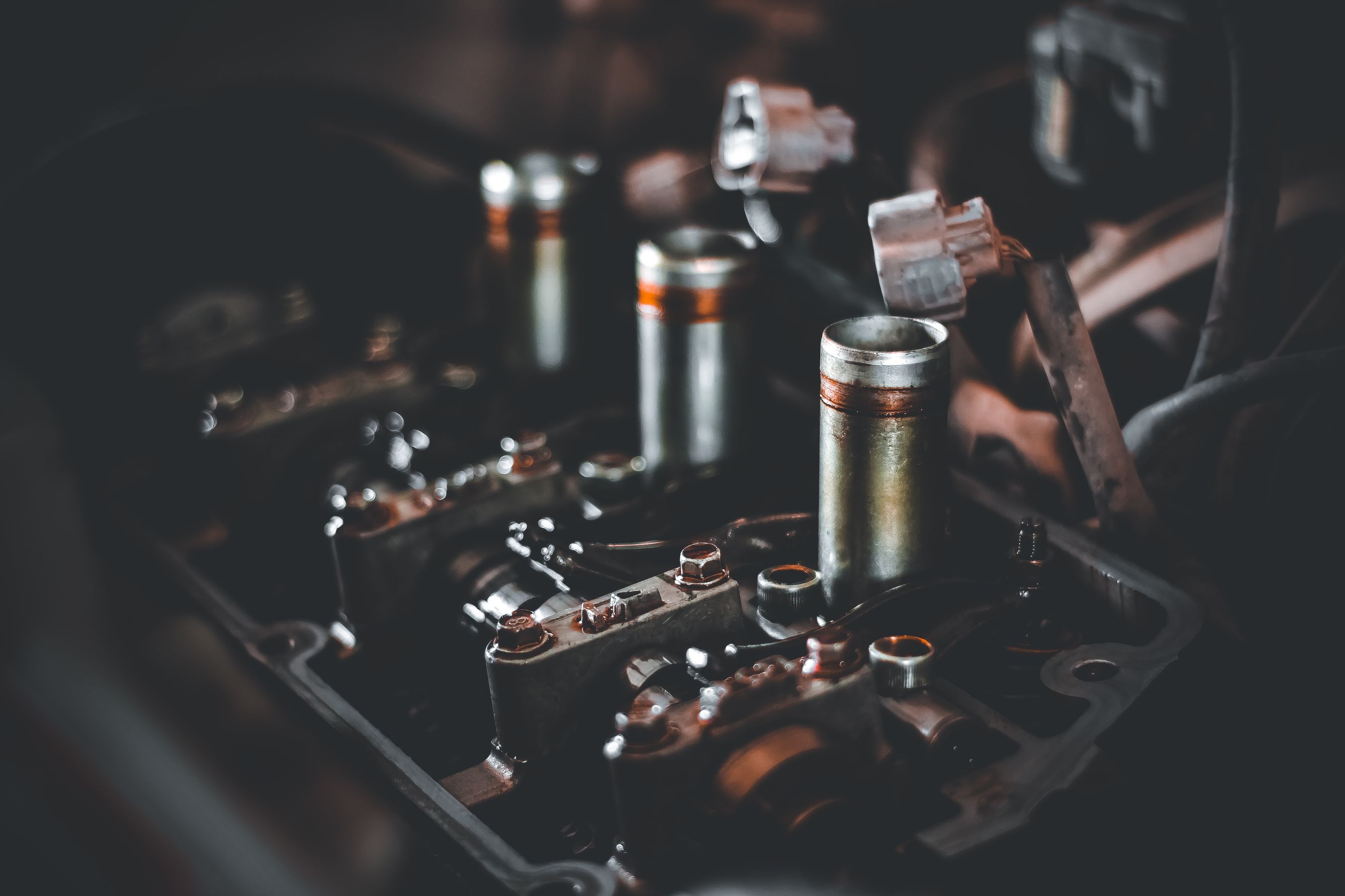 Engine valve cover showing exposed spark plug wells and ignition coil pack connectors before DIY replacement