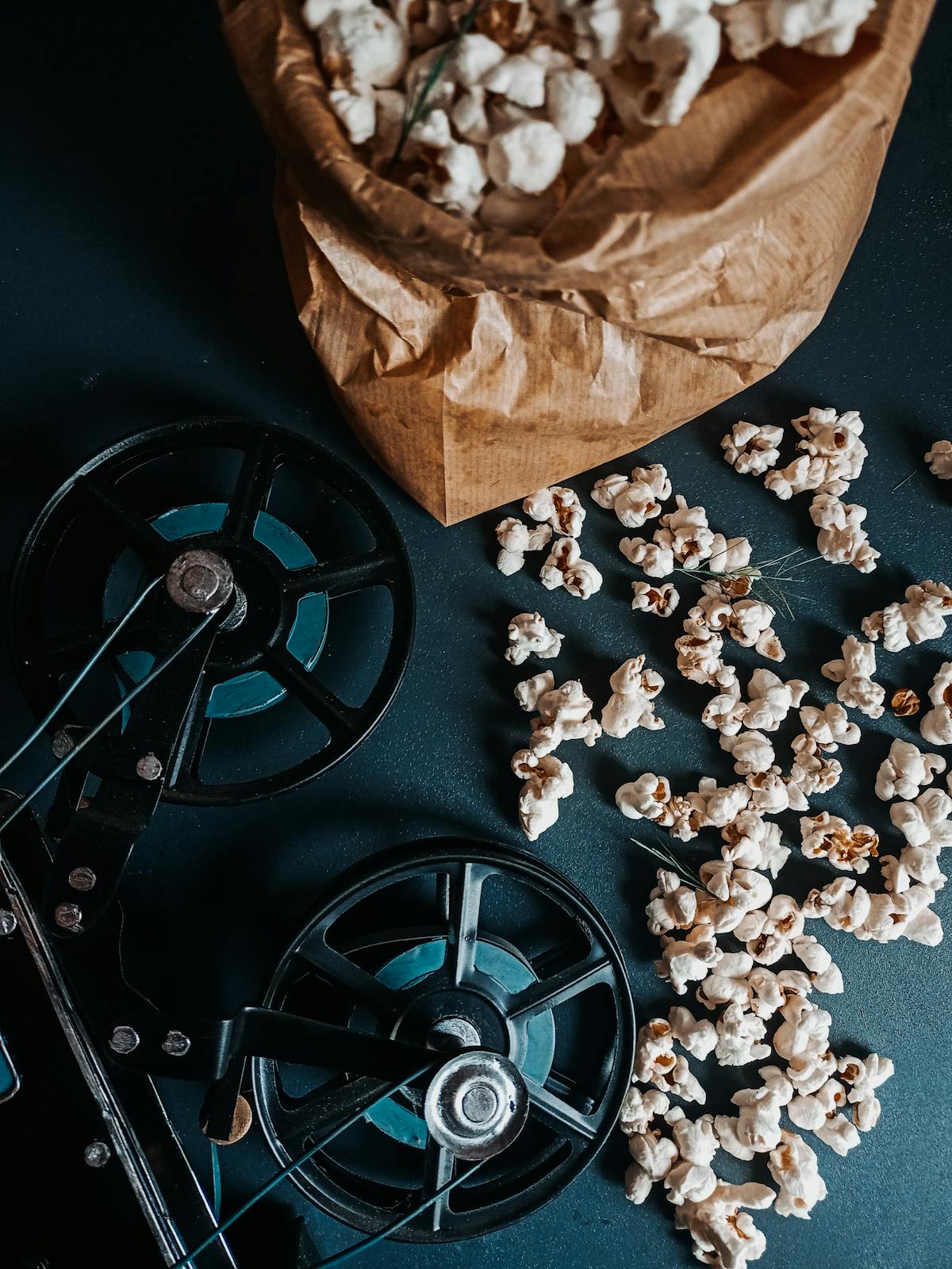 Sacchetto di carta pieno di popcorn posizionato su una bobina di film