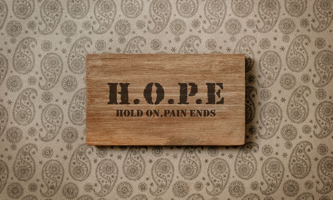 rustic wooden sign with motivational h o p e message on patterned wall