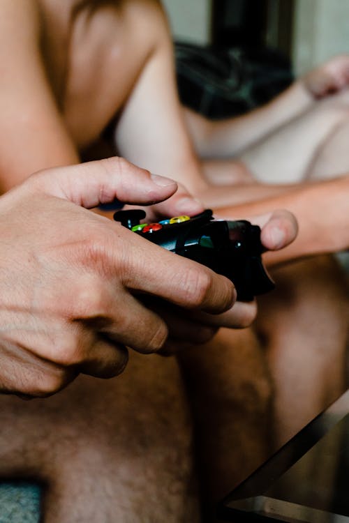 A Person Holding a Black Controller