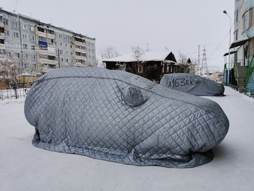 Covered Cars on Parking Lot in Town During Winter