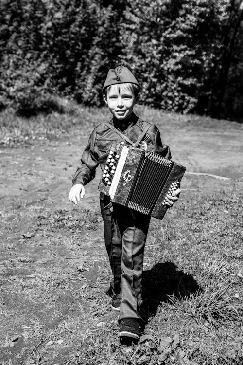 Grayscale Photo of a Boy with an Accordion
