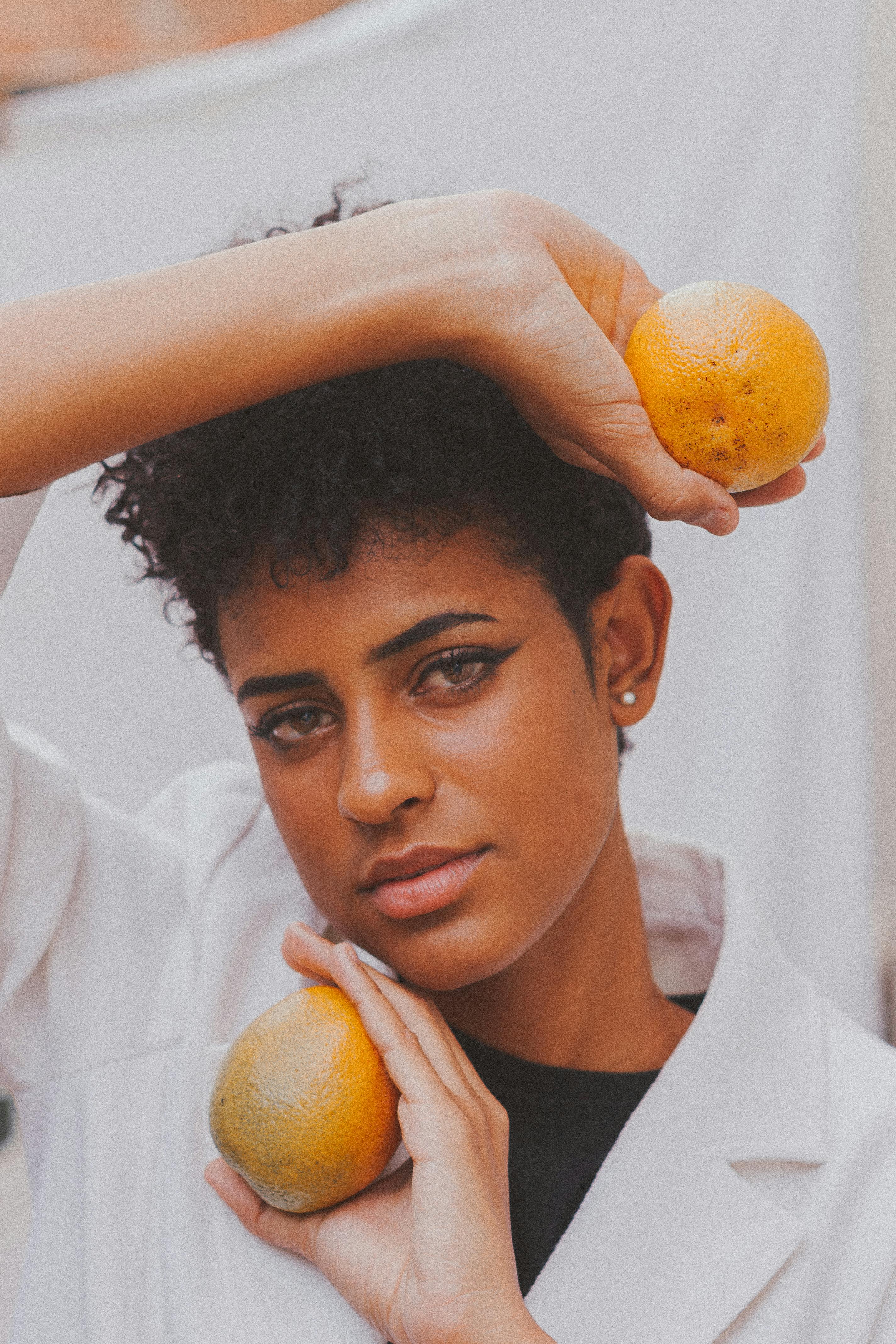 Captivating portrait of a woman with oranges in a unique composition.