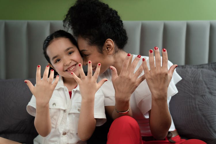 A Woman And Girl Showing Their Manicured Nails