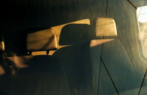 Free Sunlit view of car seats seen through a window, creating a warm and reflective atmosphere. Stock Photo