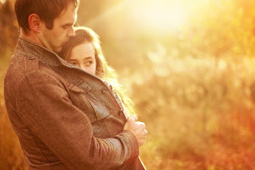 Free Photo of a Man Covering a Woman with His Coat Stock Photo