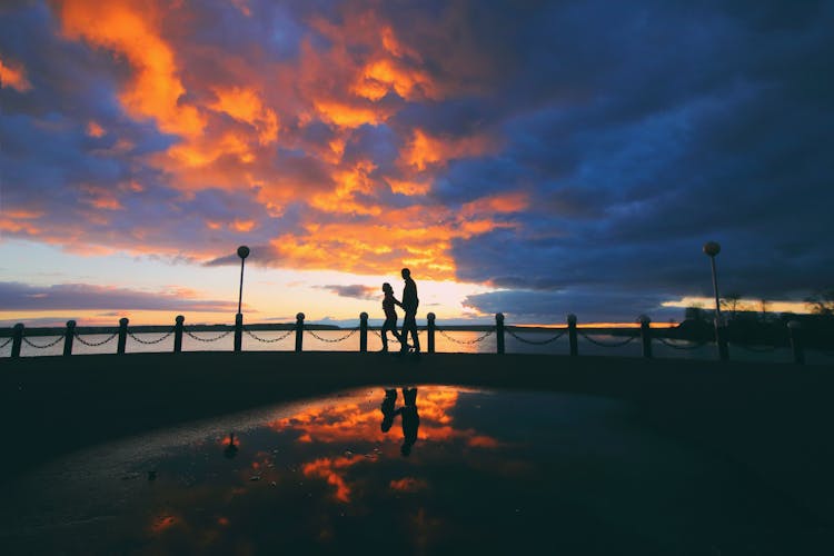 Silhouette Of A Couple Walking Together During Sunset