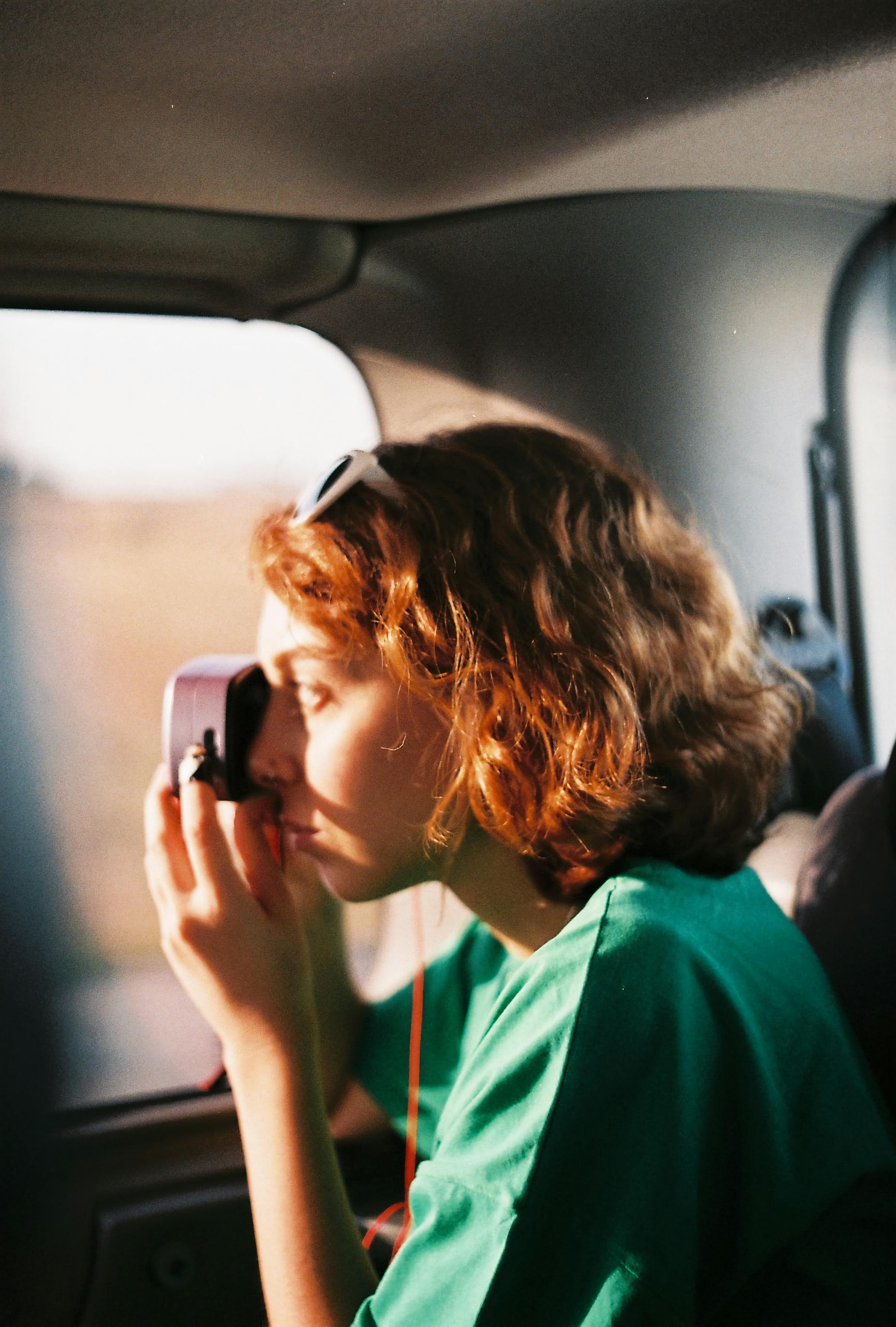 side profile of a woman in green shirt taking a photo