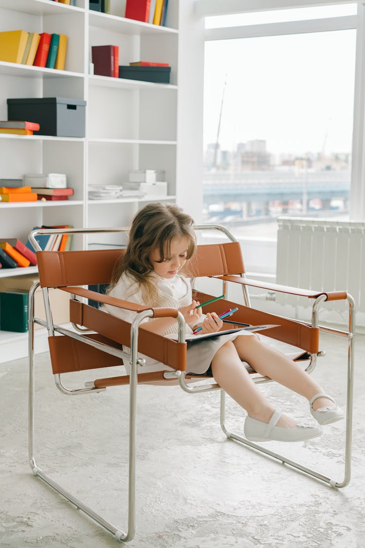 A Girl In White Dress Sitting On A Chair