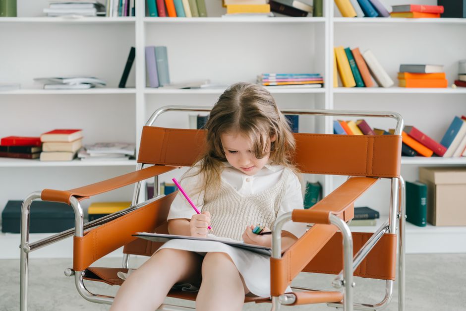 Photo by Mikhail Nilov on Pexels Caucasian girl sitting in a chair drawing with colored pencils in a cozy home library. - Photo by Mikhail Nilov on Pexels