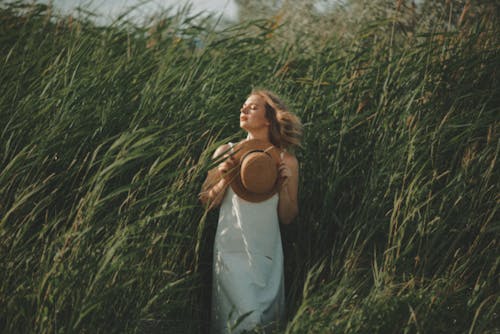 Woman Wearing White Dress Standing Beside Tall Grass
