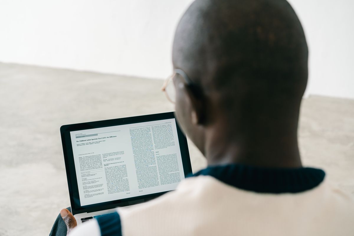 A person reading a document on a laptop