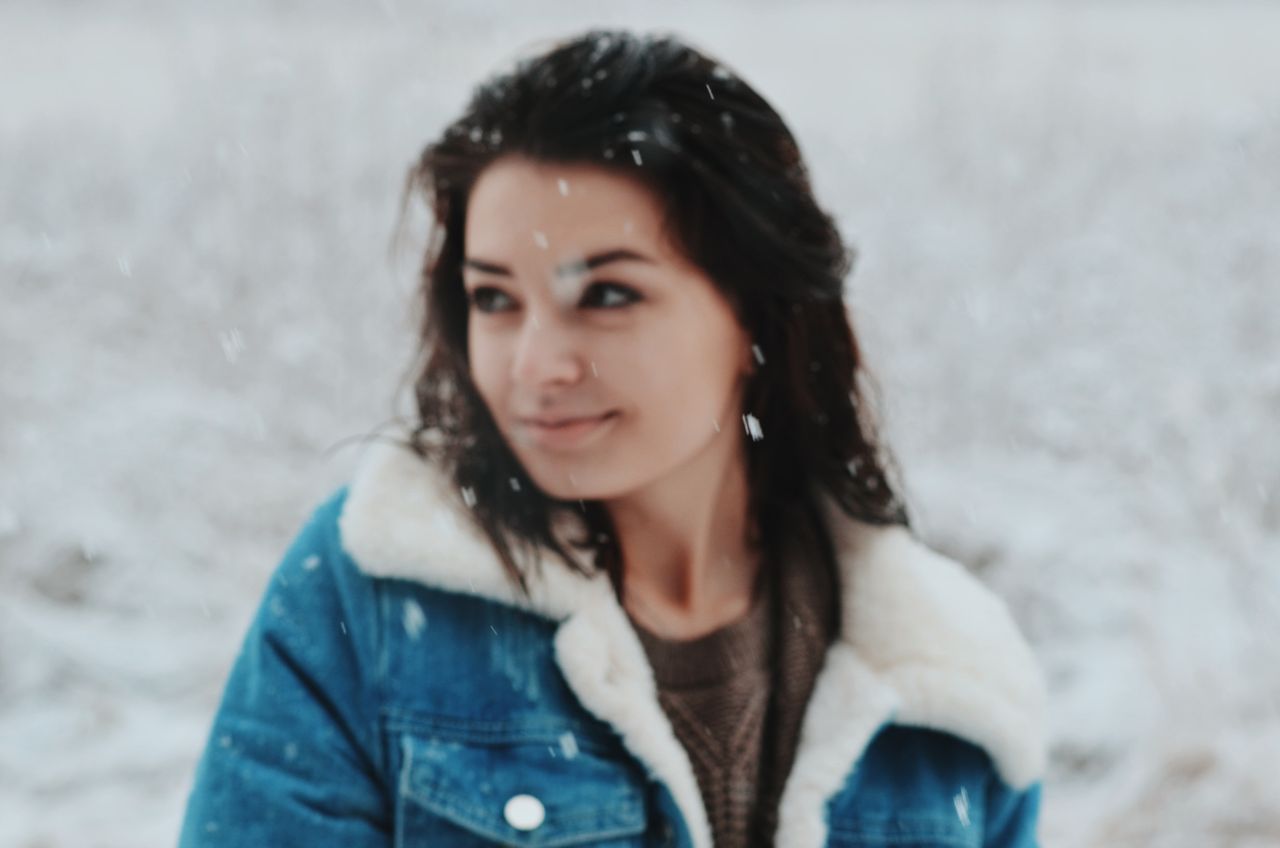 Woman in a denim jacket with a shearling collar in falling snow