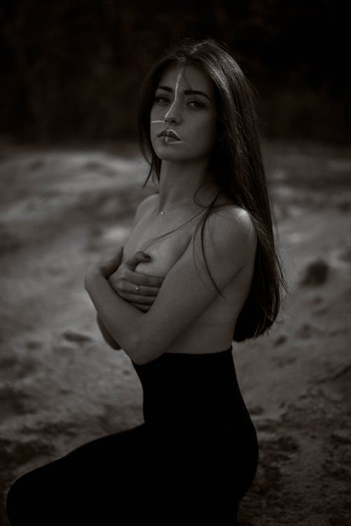 Grayscale Photo of a Shirtless Woman with Face Paint