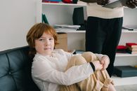 Girl in White Long Sleeve Shirt Sitting on Black Chair