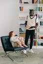 Man in Black and White Long Sleeve Shirt Carrying Baby in White Onesie