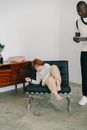 Woman in White Long Sleeve Shirt Sitting on Black Sofa