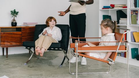 Children engaging in a therapy session with therapist in a modern office.