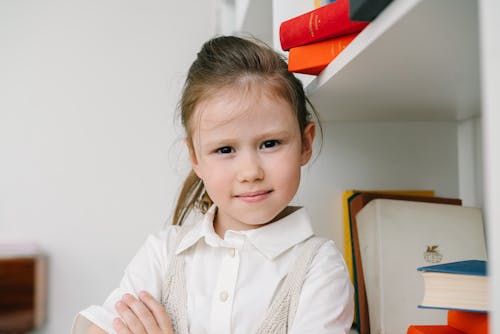 Girl Standing Beside Bookshelves