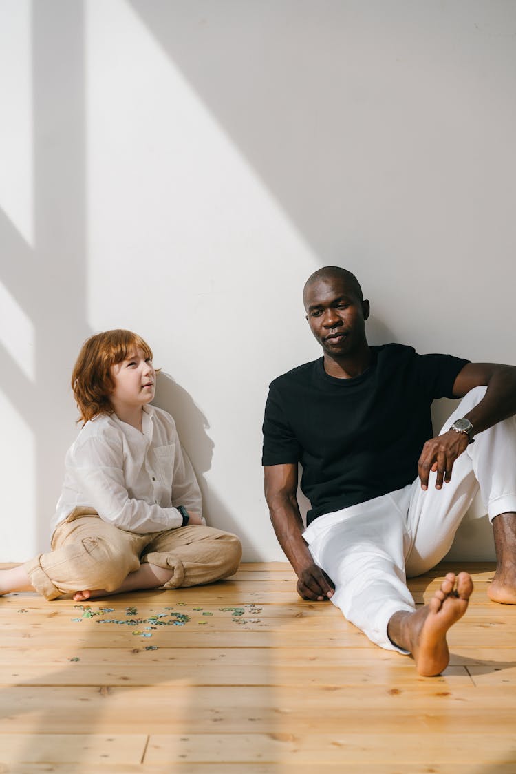 Man And Redhead Boy Sitting On Floor