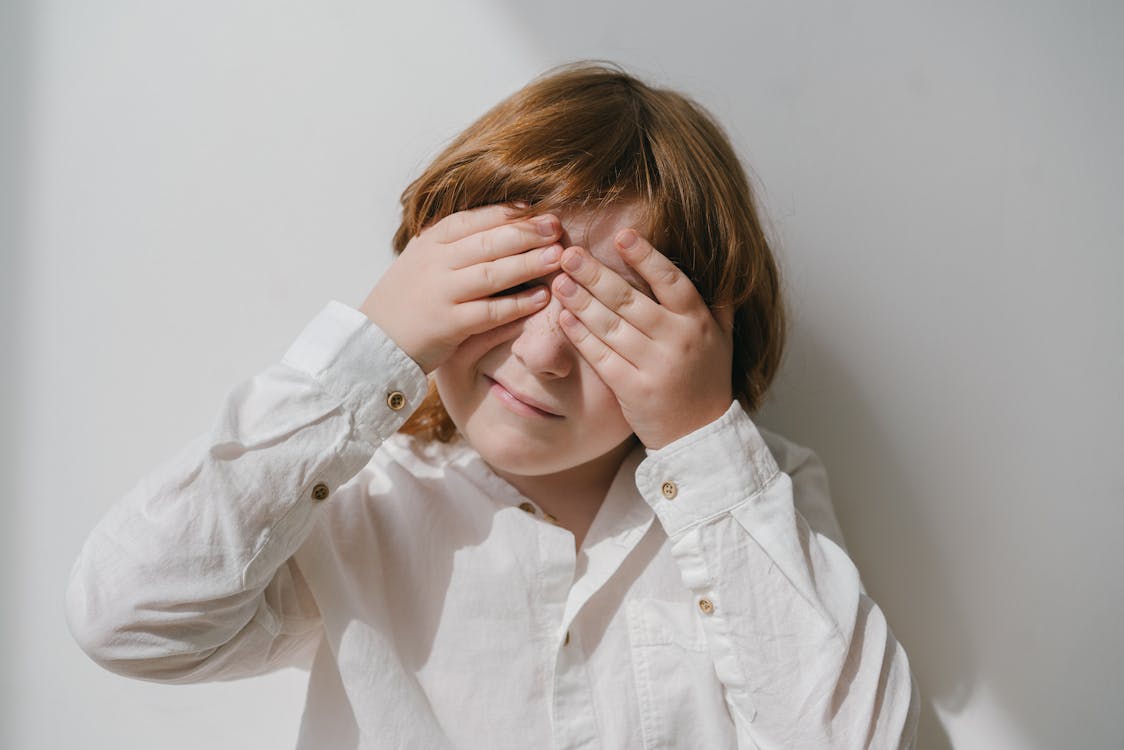 Free Photograph of a Boy Covering His Eyes Stock Photo