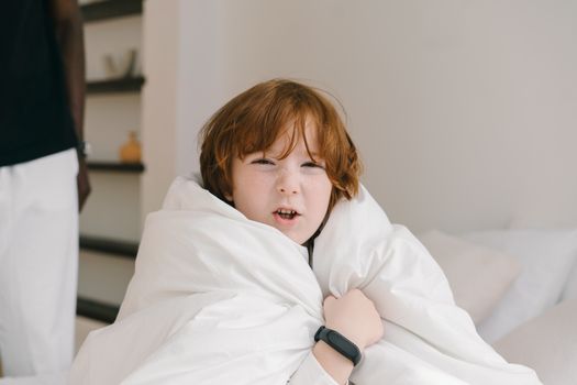Photo of a Boy with Red Hair Holding a White Blanket