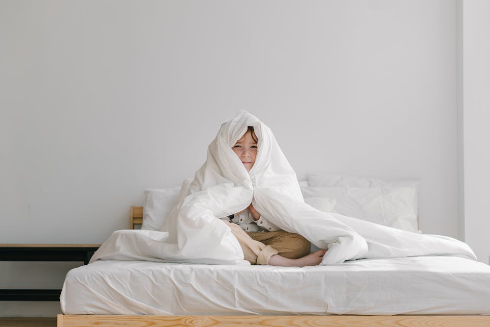 Boy wrapped comfortably in comforter