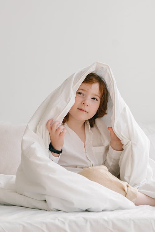 Free Redhead Boy under Duvet Stock Photo