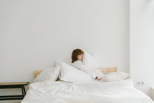 Free Boy in White Long Sleeve Shirt Hugging White Pillow Stock Photo