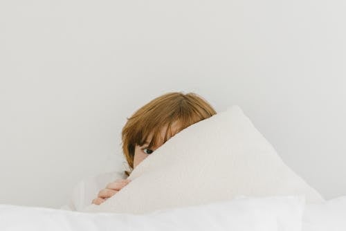 Close-Up Shot of a Boy Covering His Face With a Towel