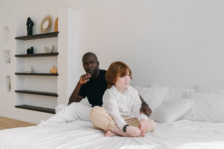 Vater tröstet seinen Sohn im Kinderzimmer