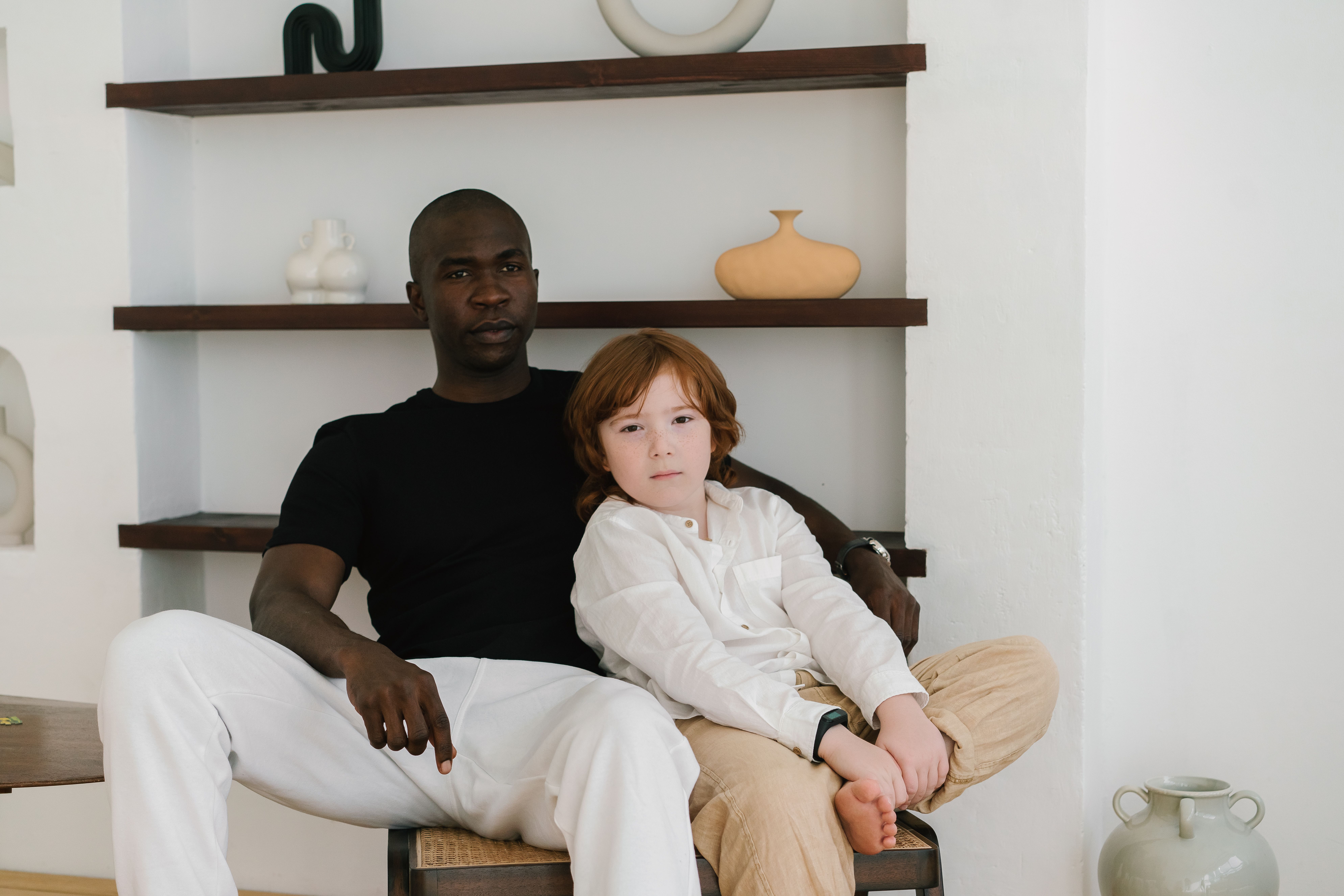 A father and son sitting comfortably indoors, showcasing family bond and relaxation.