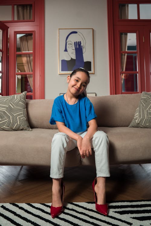 Girl Wearing a Blue Shirt Sitting on a Couch
