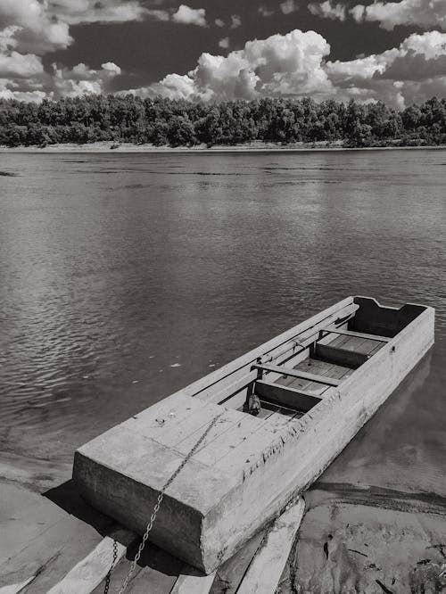 A Grayscale Photo of a Wooden Boat on the Lake