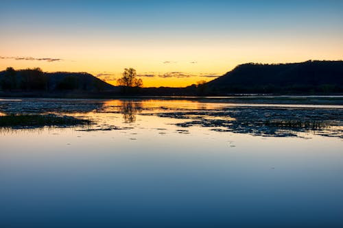 Silhouette of Mountains near the Lake during Sunset