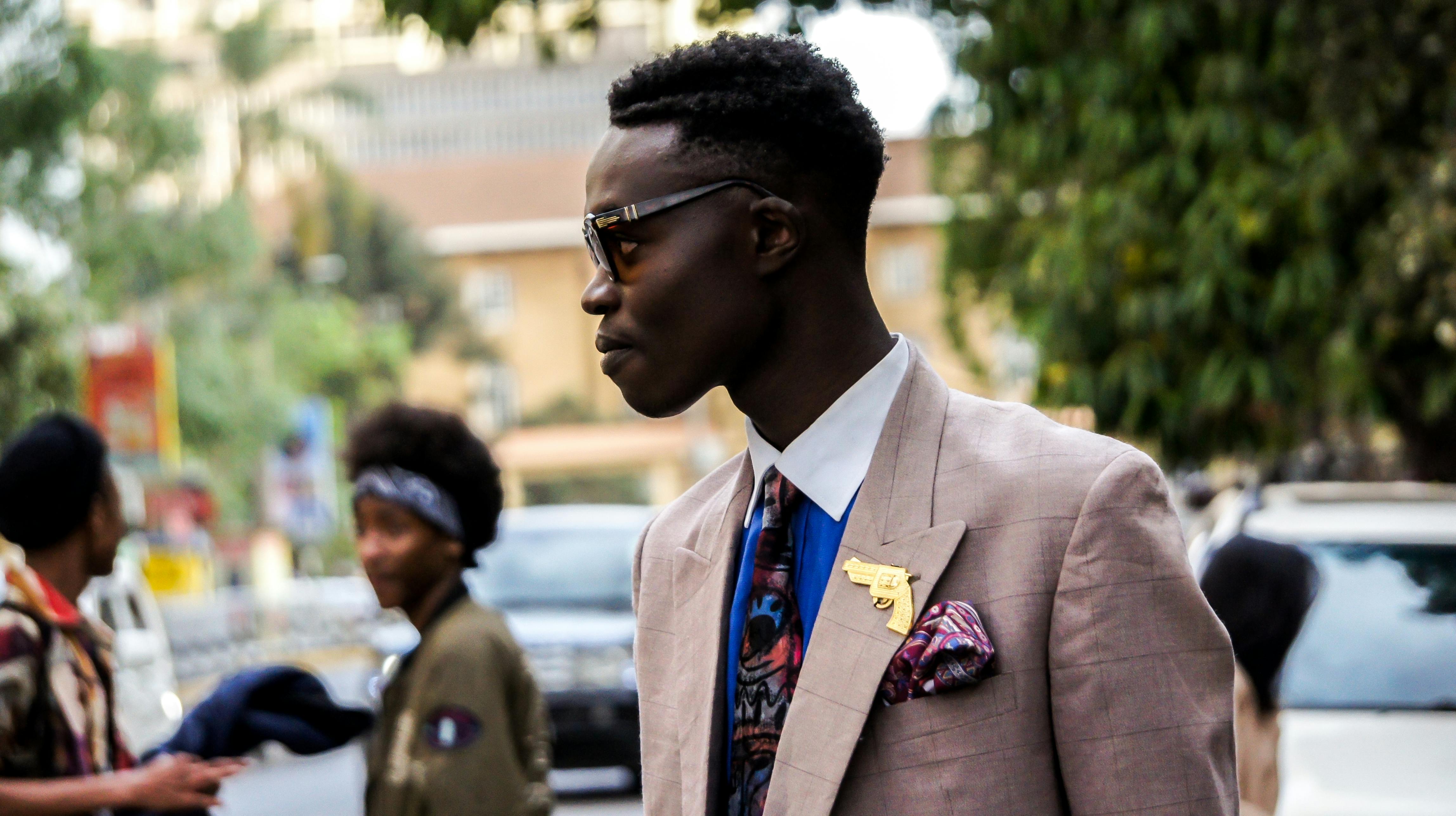 A fashionable man in Nairobi showcases modern street style with chic attire and accessories.