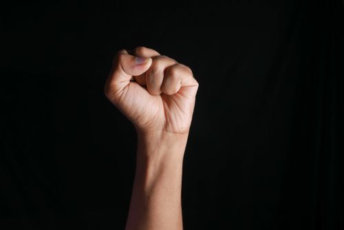 Free A raised fist against a dark background symbolizing strength, determination, and solidarity. Stock Photo
