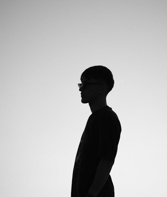 Black and white silhouette of a man in profile against a bright sky, creating a dramatic and artistic effect.