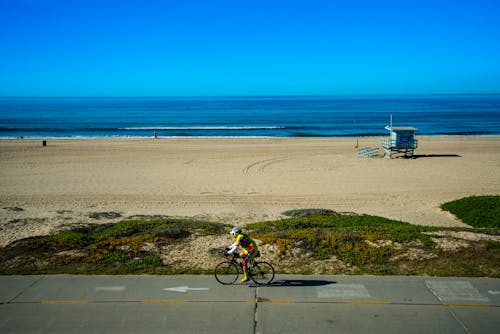 Free Lonely cyclist riding bike near seashore Stock Photo