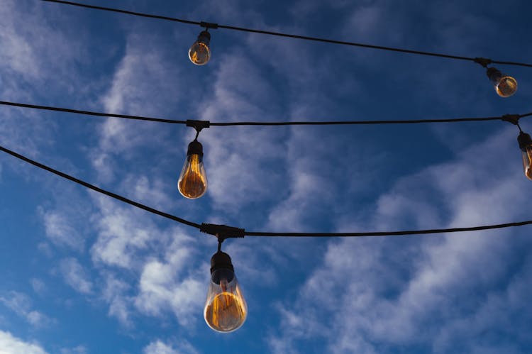 Hanging Lightbulbs Under A Blue Sky